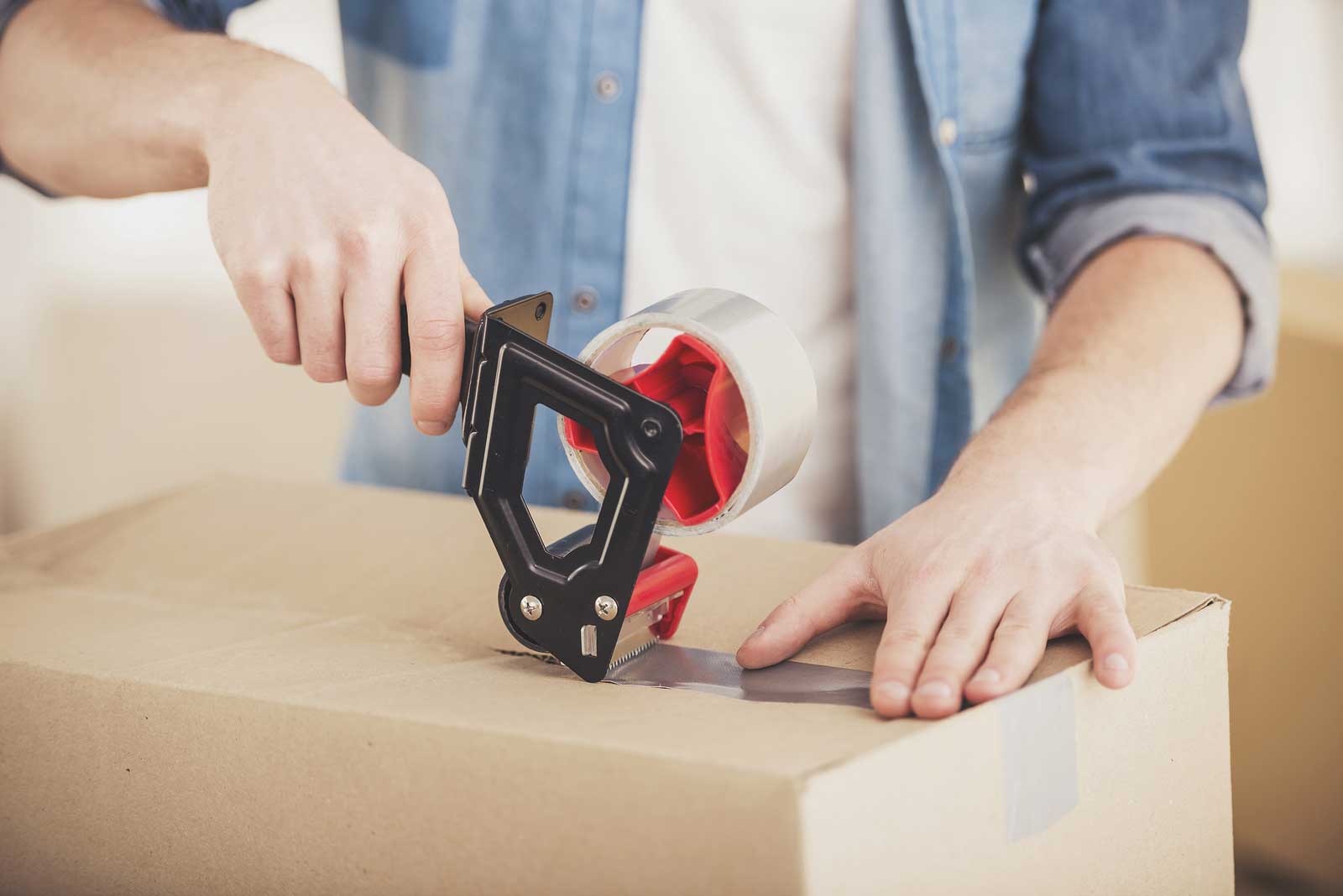 Young man tapes box to put in self storage.