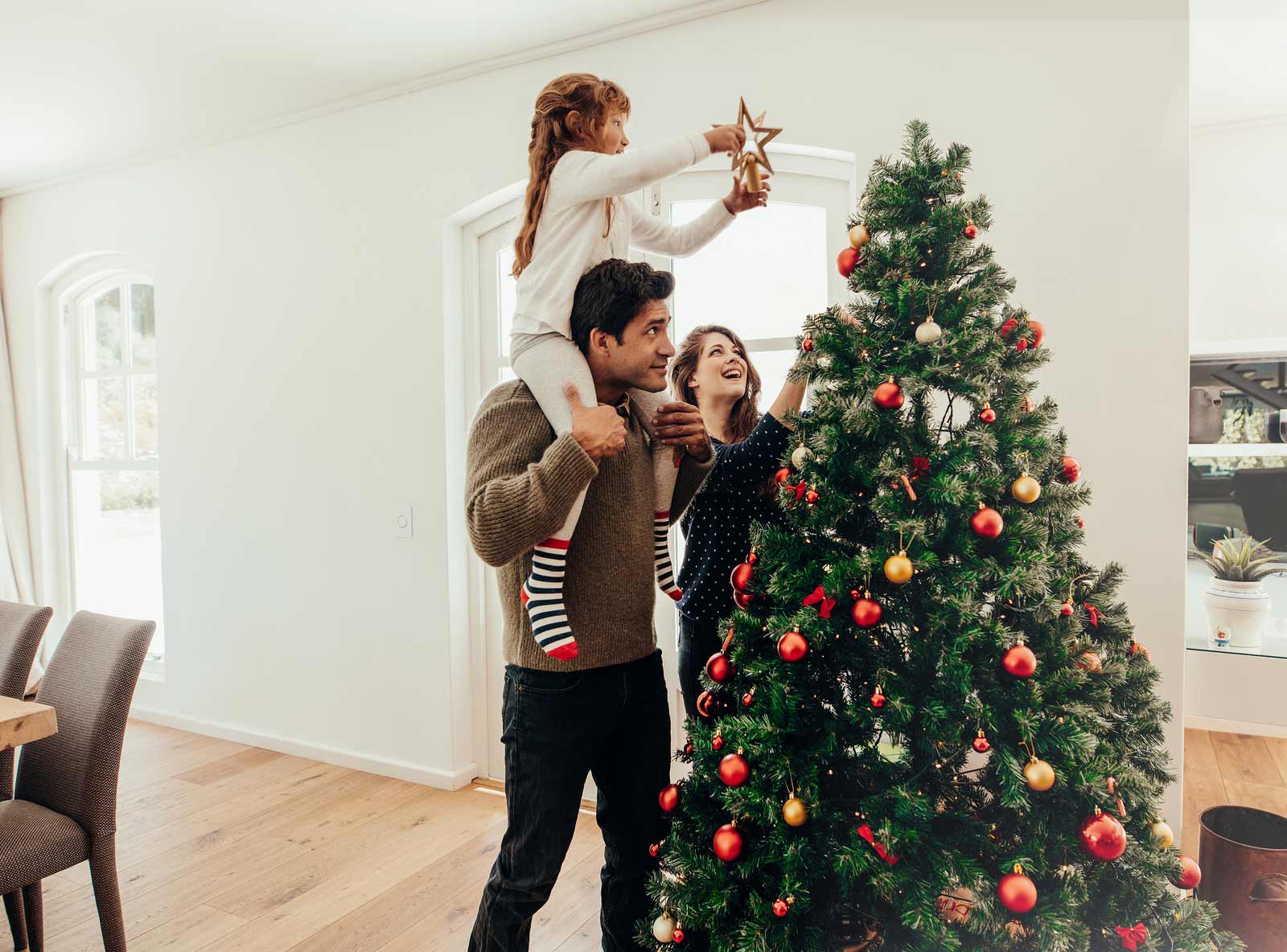 Une famille prépare son arbre de Noël pour les vacances des fêtes.