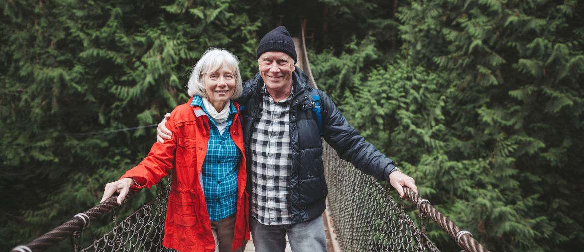 A retired couple crosses a rope bridge