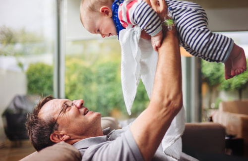 A middle aged man plays with a baby