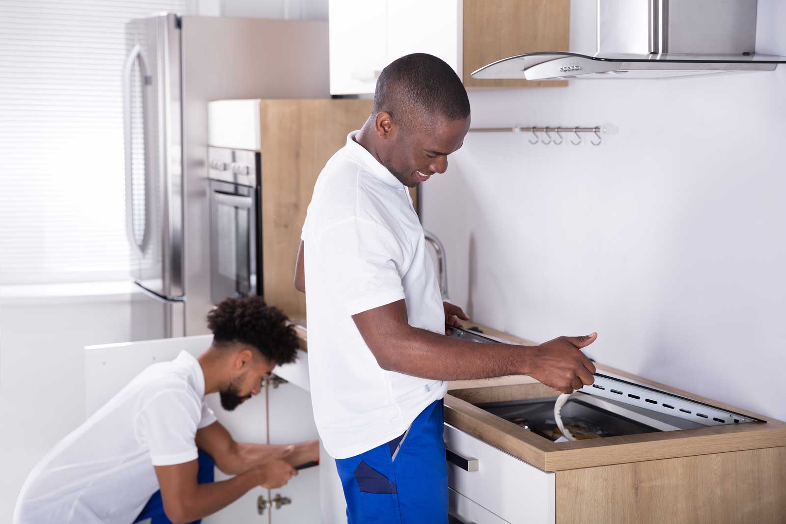 Two men prepare a stove and oven for a move to self storage