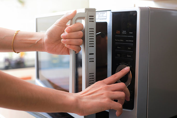 A woman prepares a microwave for a move to self storage