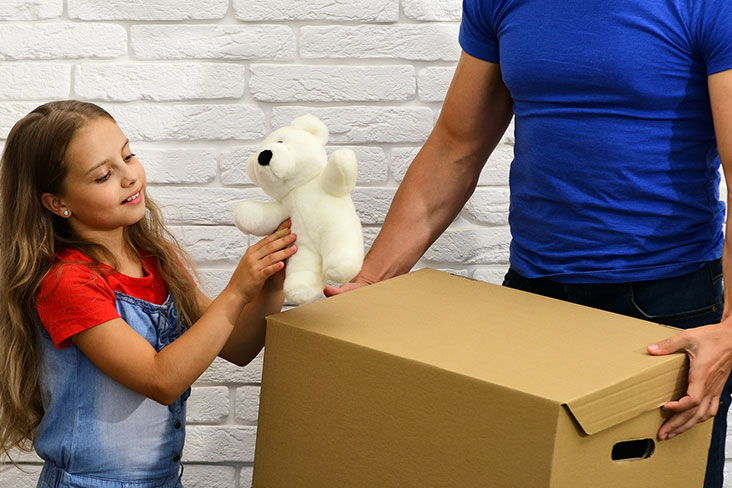 Niña prepara un juguete viejo para almacenamiento