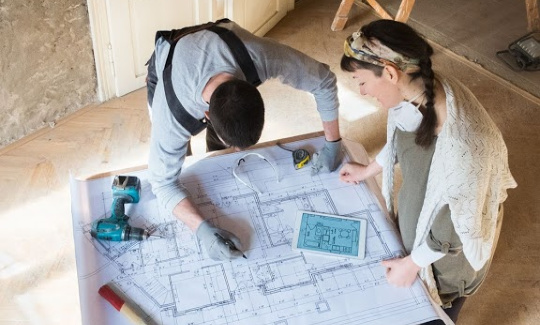 a contractor and client looking at blueprints