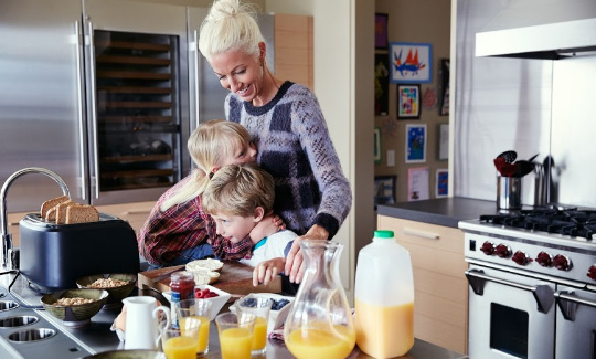 a mother makes breakfast with her children