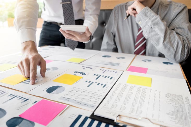 Profesionales de negocios revisan documentos importantes antes de empacarlos para almacenamiento.